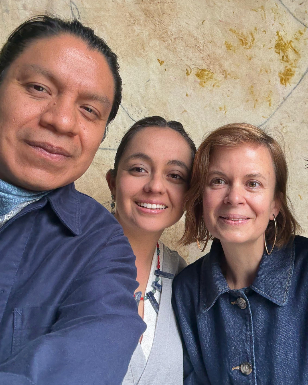 1 of 5, Three people, all medium and light skin, smile at camera. 